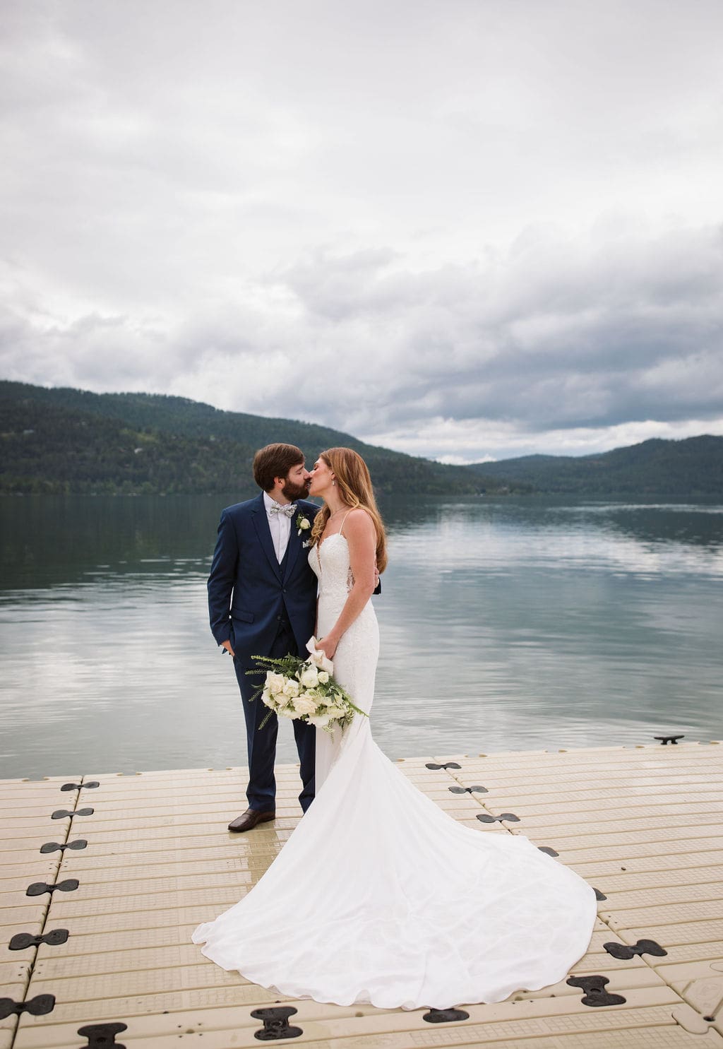 Bride and groom kissing on dock at the Lodge at Whitefish Lake