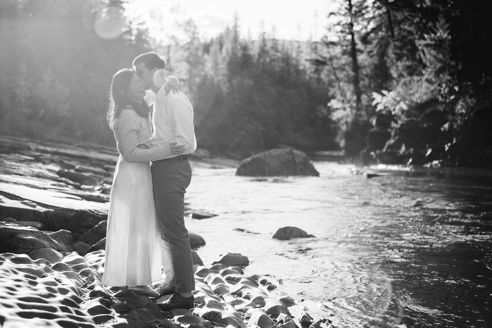 Couple standing by river during their engagement session with Montana wedding photographer.
