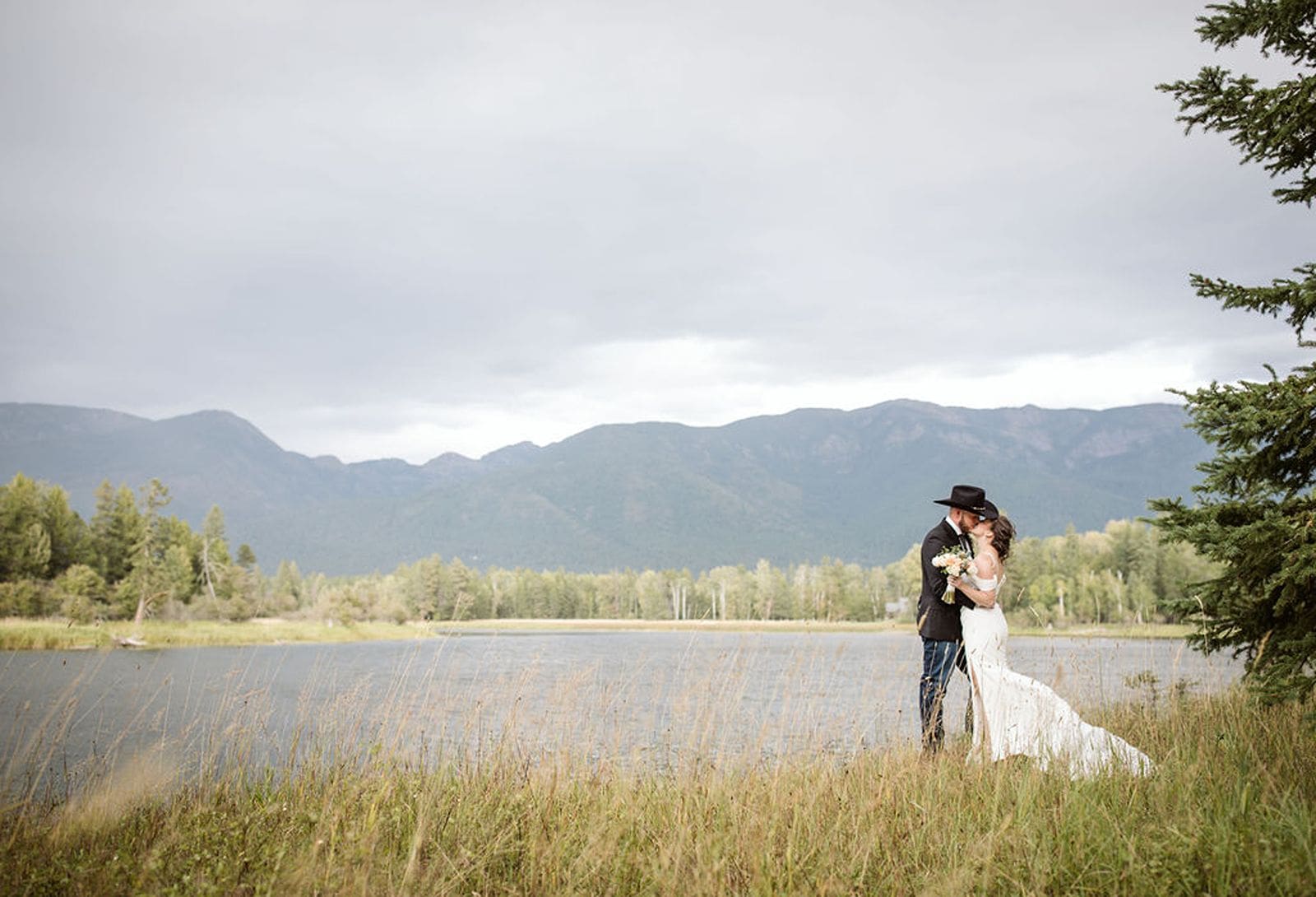 Couple standing next to river at Bigfork Wedding. 

