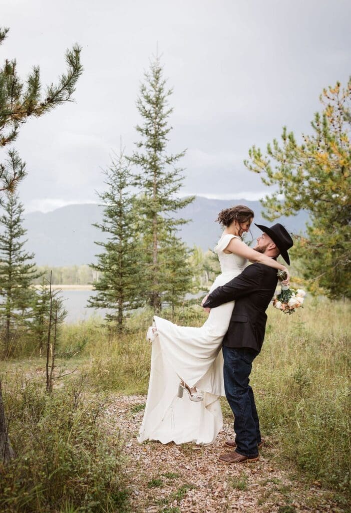 Groom picking up bride during bridal portraits at Bigfork wedding. 