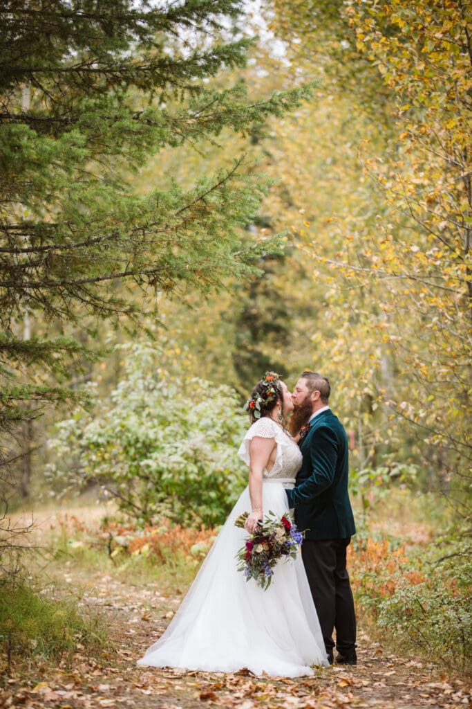 Couple kissing on a path with fallen leaves at Paddle Ridge. 